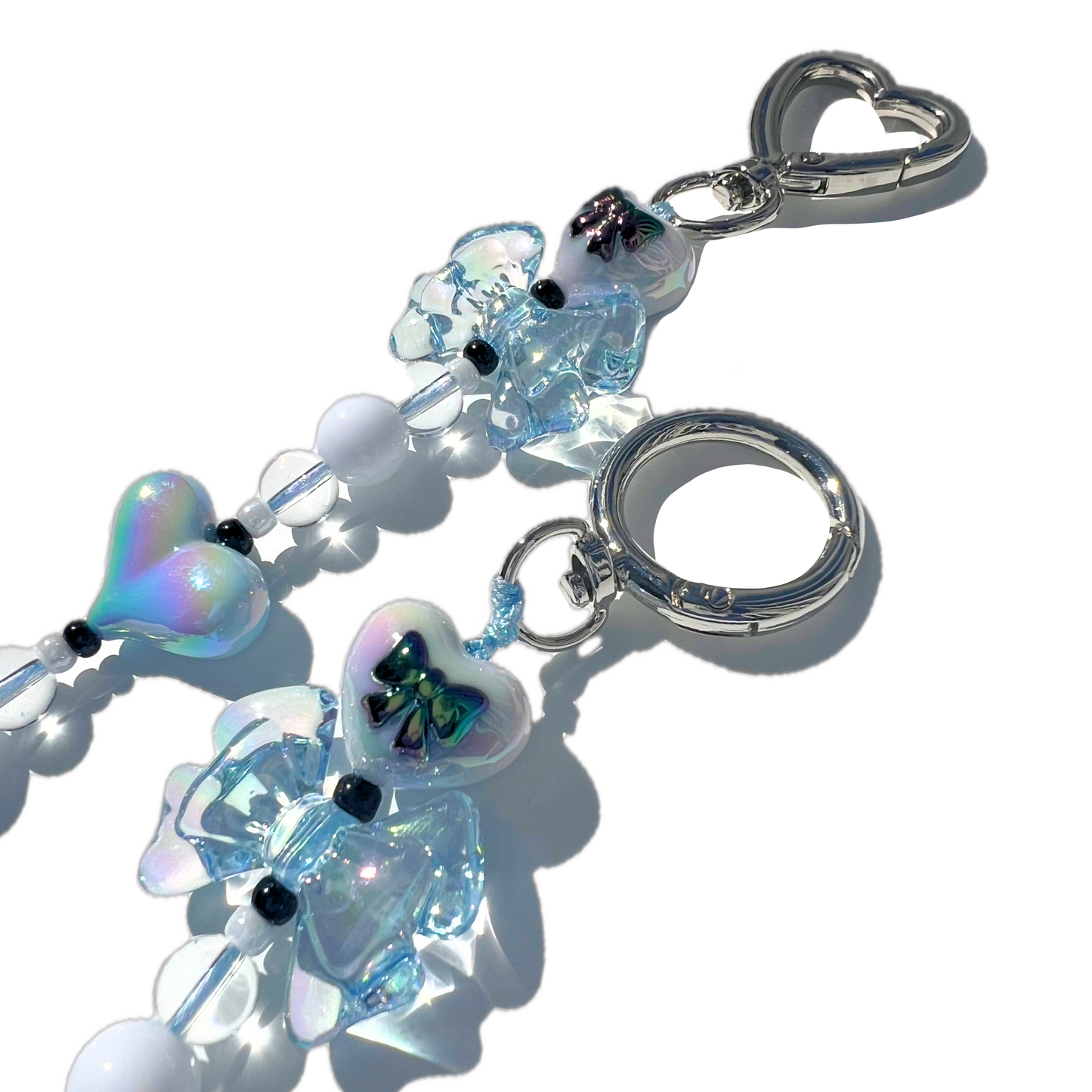 Handmade coquette style baby blue heart and bow bag charm with iridescent beads and silver hardware